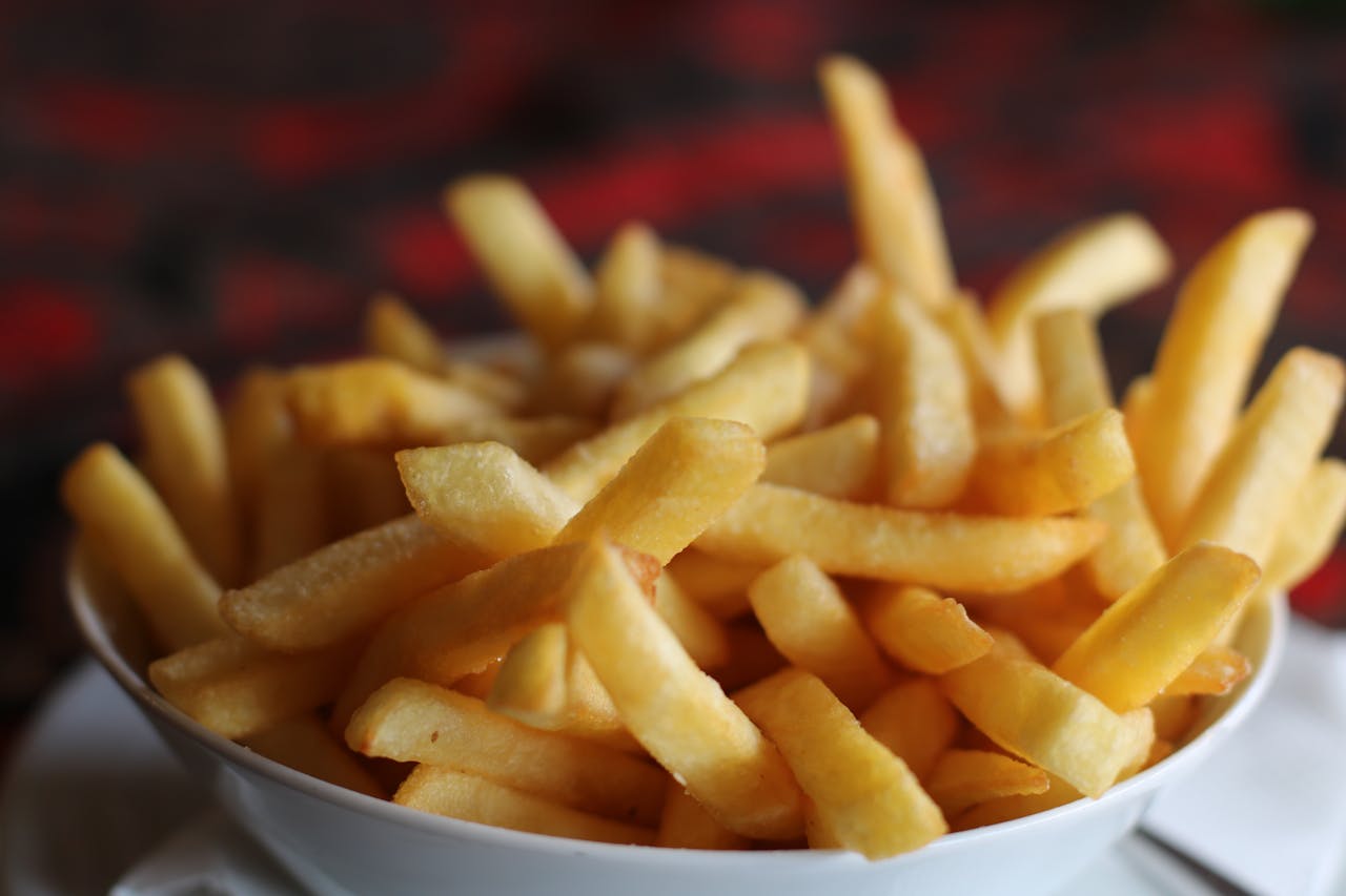home-hero-1 Delicious crispy golden french fries served in a white bowl, perfect for a tasty snack.